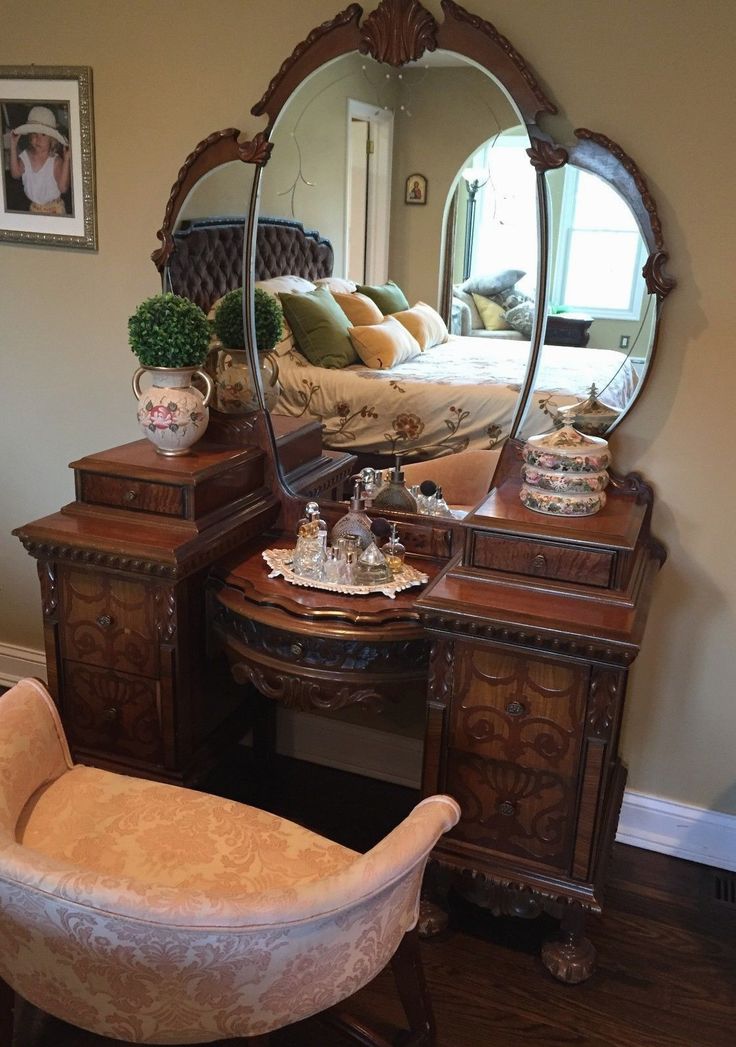 a bedroom with a dressing table, mirror and chair