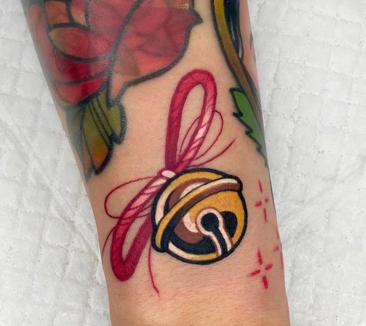 a person with a tattoo on their foot has a flower and a bell in it