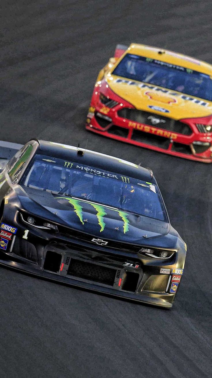 two cars racing on a race track during the day