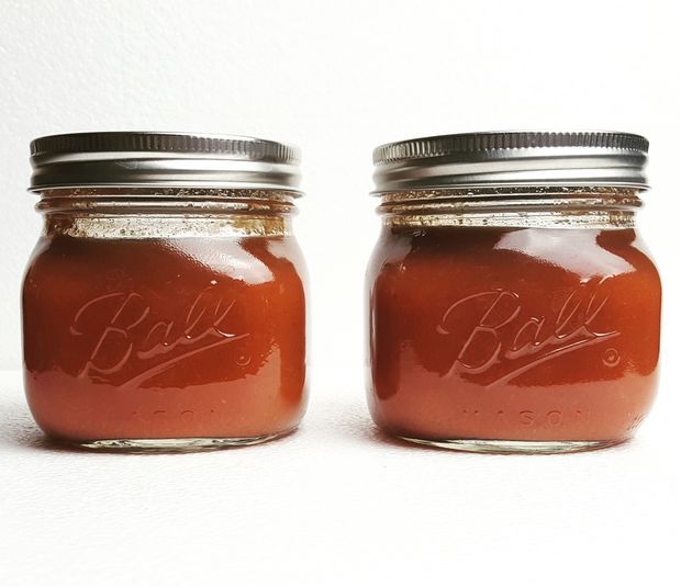 two jars filled with red liquid sitting next to each other