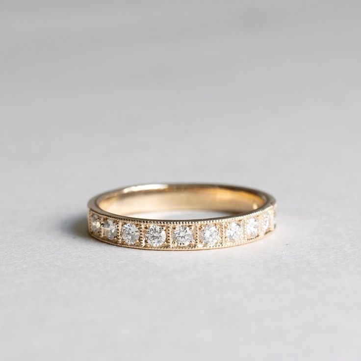 a gold wedding band with five diamonds