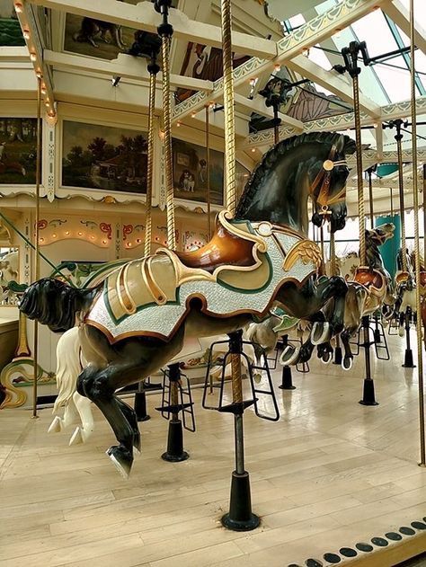 a carousel with several horses on it in a mall