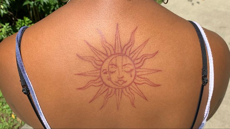 a woman with a sun tattoo on her back