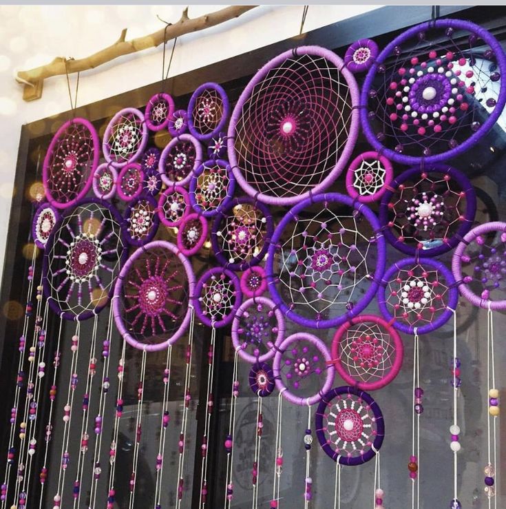 purple and white decorations hanging from the side of a building in front of a window