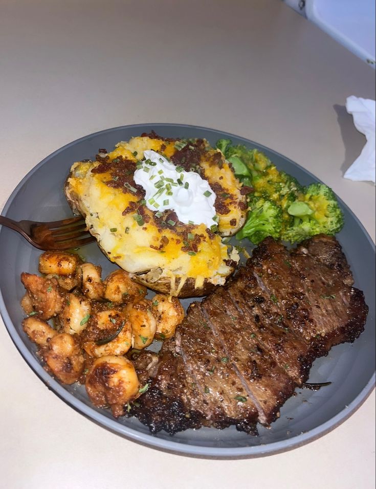 a plate with steak, potatoes and broccoli on it