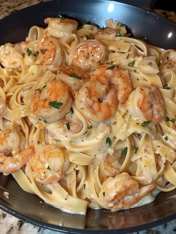 pasta with shrimp and sauce in a skillet on the stove top, ready to be eaten