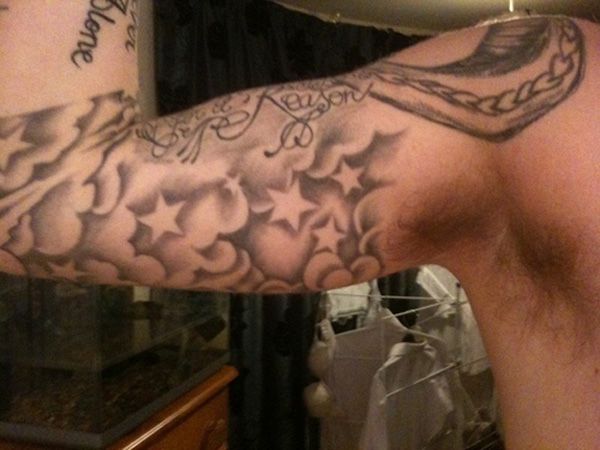 a man's arm with tattoos and writing on it