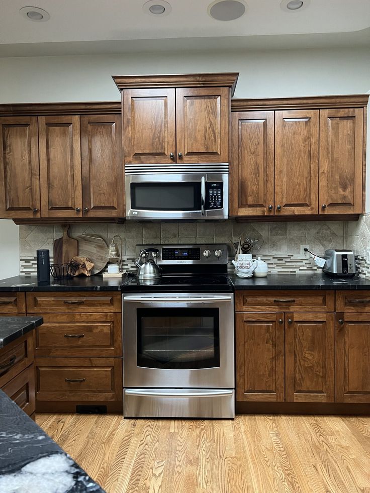 a kitchen with wooden cabinets and stainless steel appliances