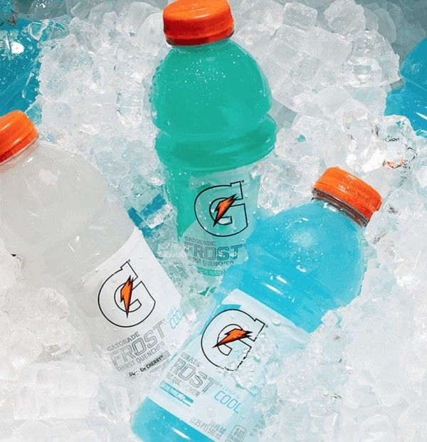 three bottled water bottles sitting in ice with orange caps on the top and one empty