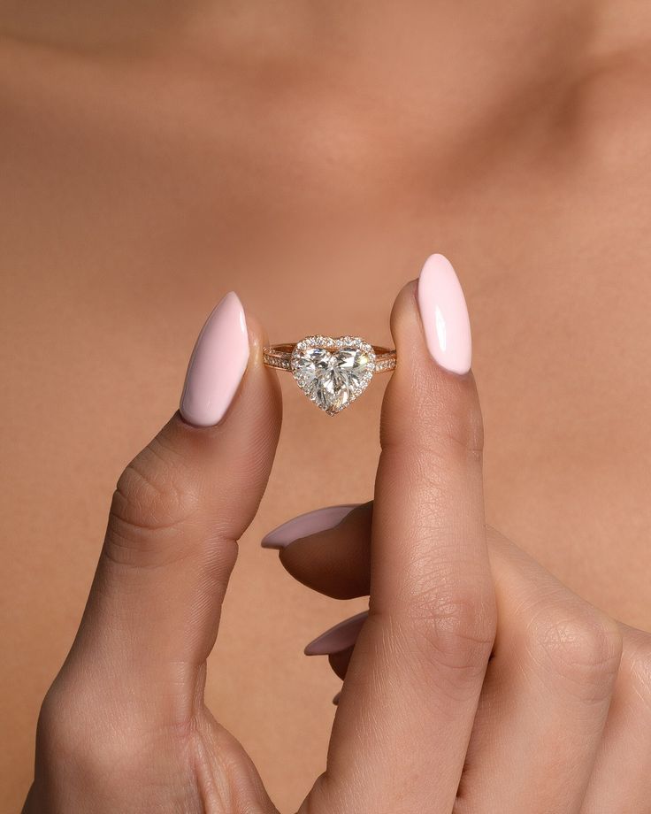 a woman's hand holding an engagement ring with a diamond on the middle finger