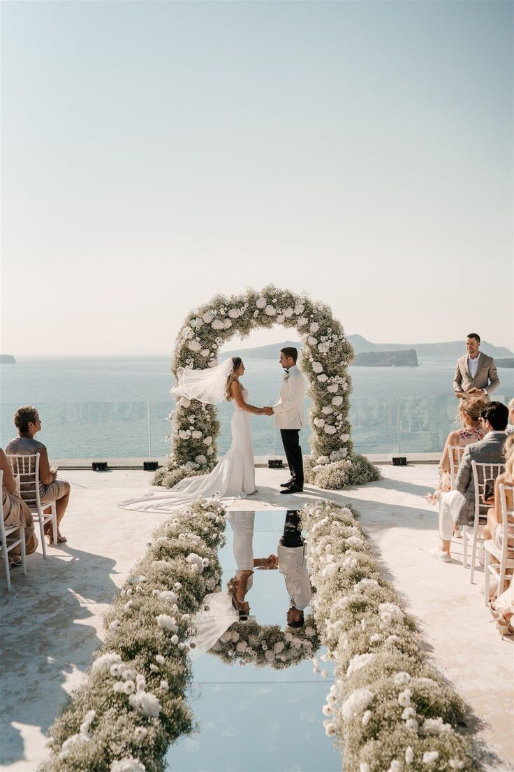 a bride and groom standing in front of an outdoor ceremony