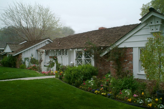 a row of white houses sitting next to each other on top of a lush green field