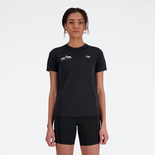 a woman standing in front of a white background wearing black shorts and a t - shirt