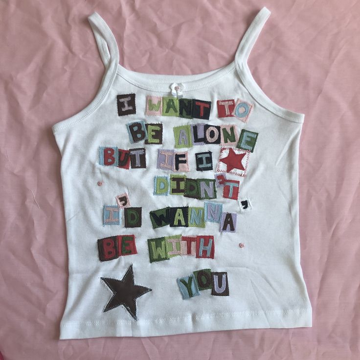 a white tank top with words written in different languages and stars on the chest,