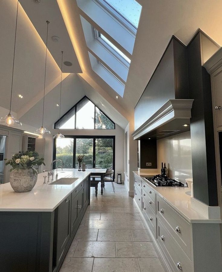 an open kitchen with skylights and white counter tops