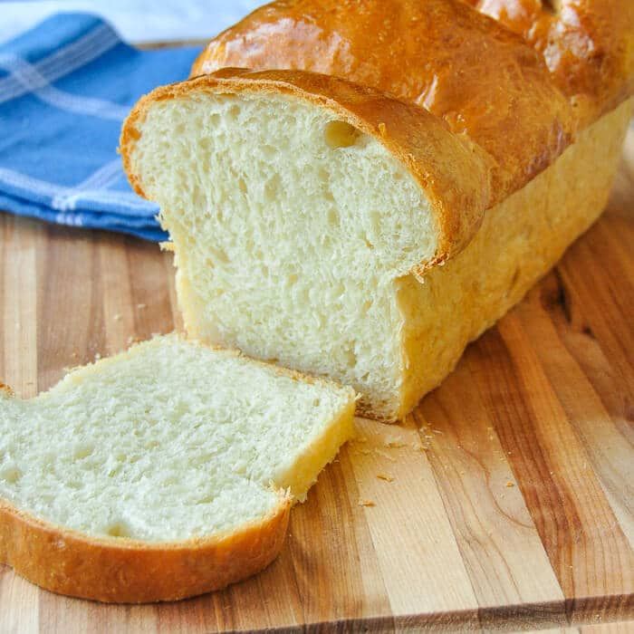 a loaf of bread sitting on top of a wooden cutting board