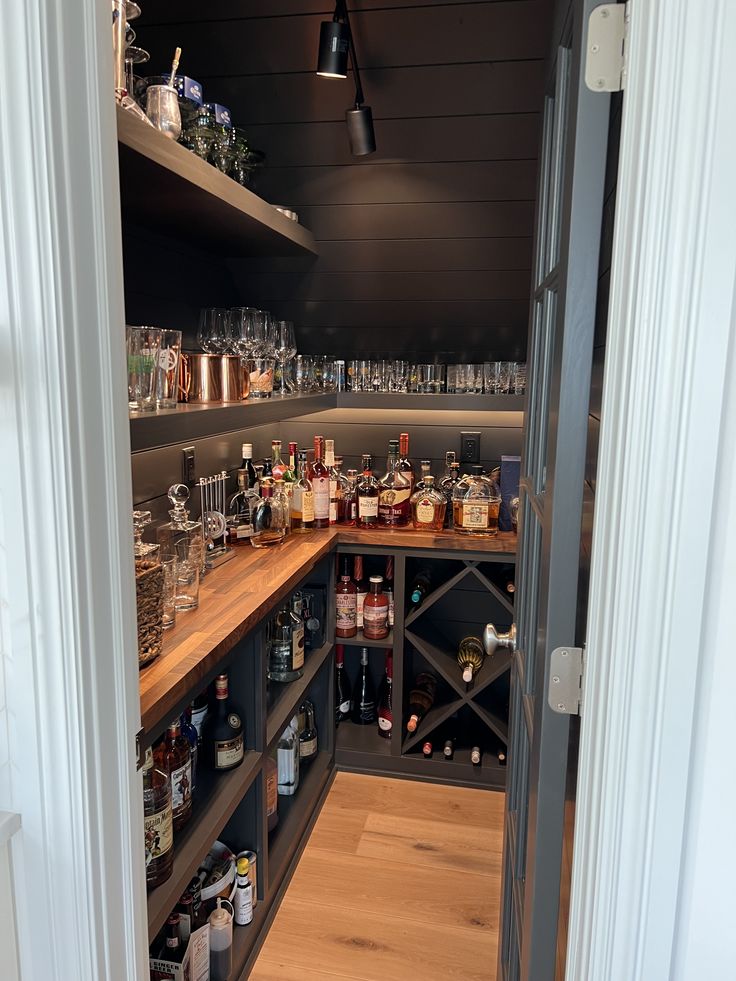 an open pantry filled with lots of bottles and glasses