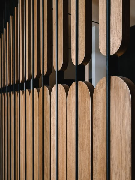 the wooden slats are lined up against the black metal wall, which has been designed to look like wood planks