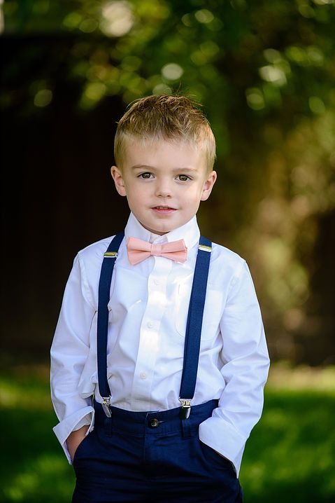 a young boy wearing a bow tie and suspenders