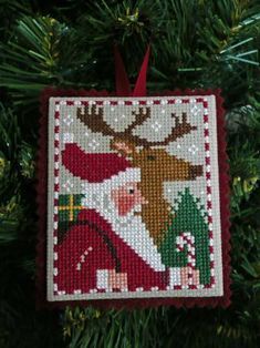 a cross stitch ornament hanging from a christmas tree