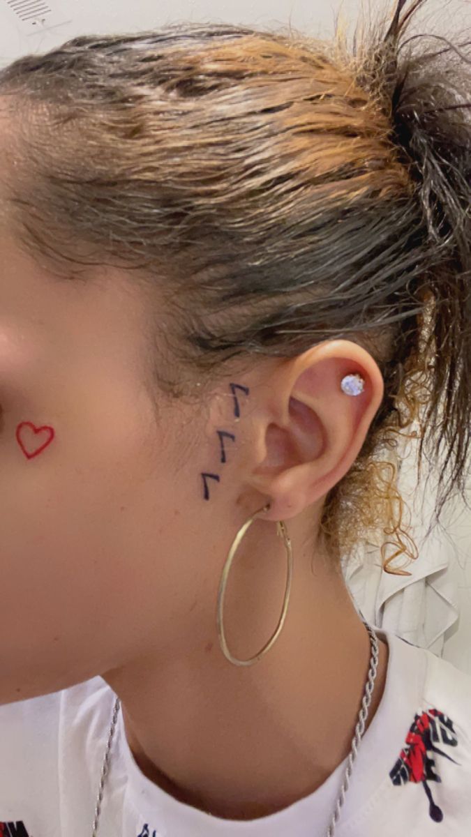 a woman with tattoos on her face and ear