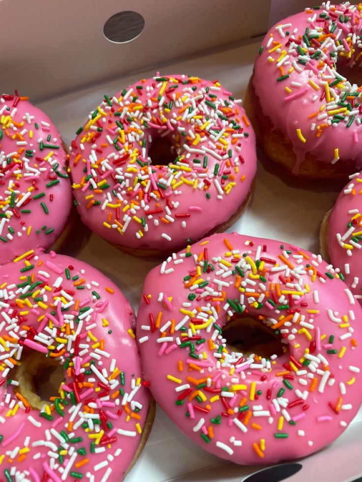 pink frosted donuts with sprinkles in a box