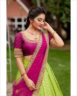 a woman in a green and pink lehenga