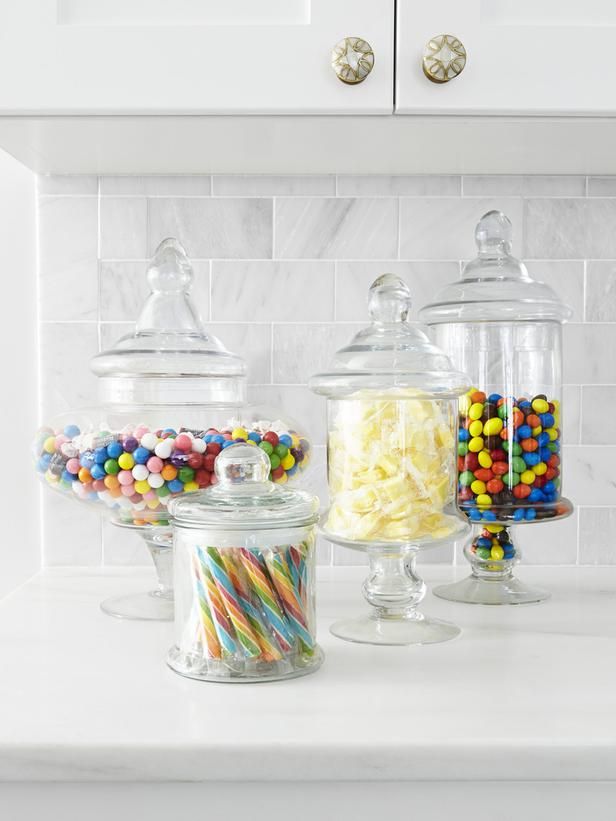 several glass jars filled with candy on top of a counter