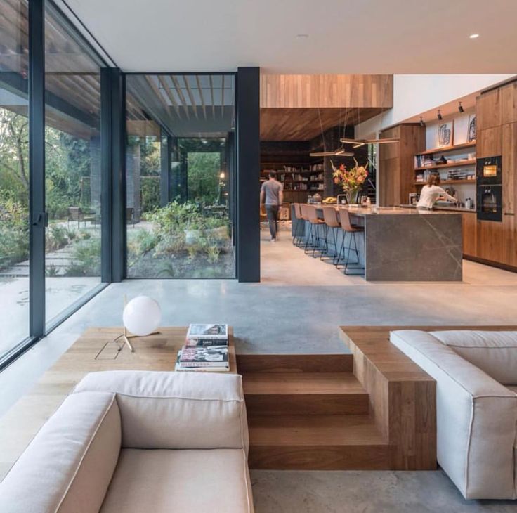 a living room filled with furniture next to a kitchen and an open floor plan on the wall