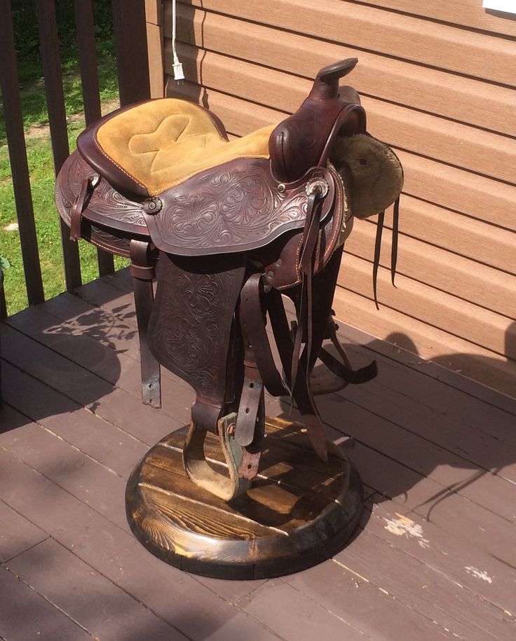 a horse saddle sitting on top of a wooden deck