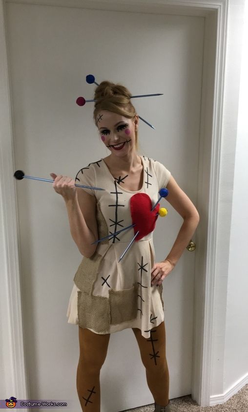 a woman is dressed up as a scarecrow and holding a red heart in her hand