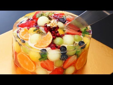 a fruit salad in a glass dish on a wooden table