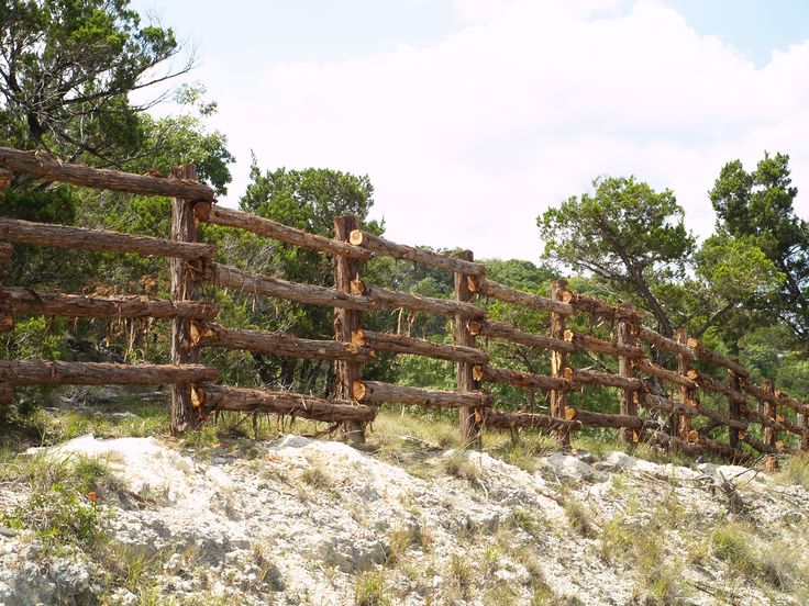 a wooden fence in the middle of a field