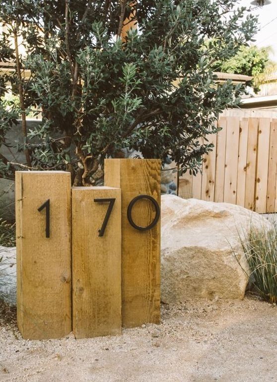 two wooden blocks with the number seventy on them in front of a tree and rocks