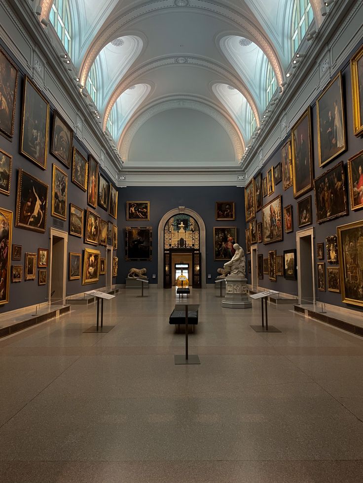 an art gallery with many paintings on the walls and ceilings, along with benches in front of them