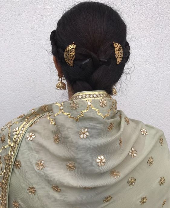 the back of a woman's head with gold hair clips on her left side