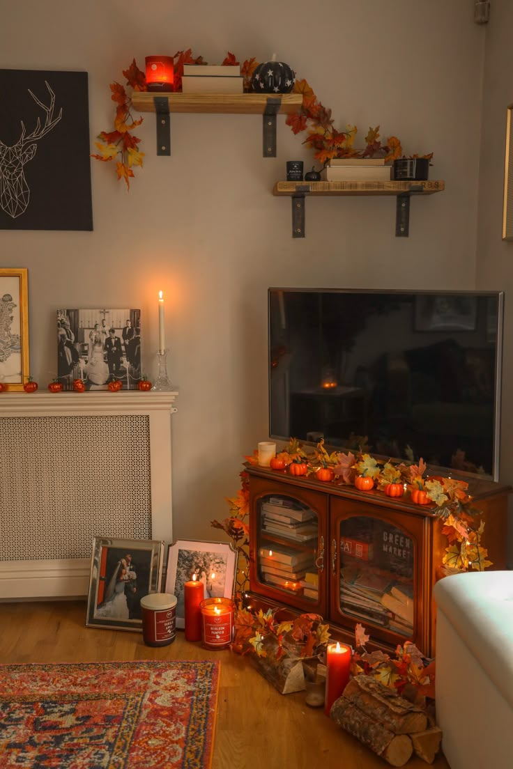 the living room is decorated for fall with candles, pictures and other decorations on display