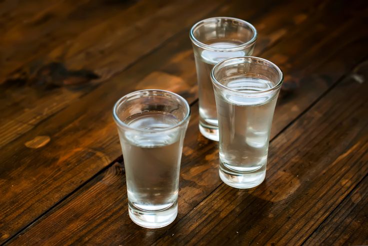 three glasses filled with water sitting on top of a wooden table