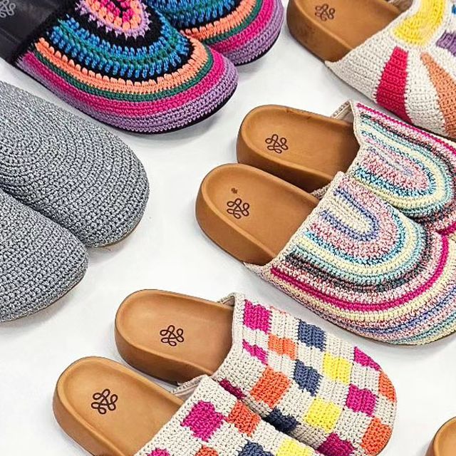 colorful crocheted slippers lined up on top of each other