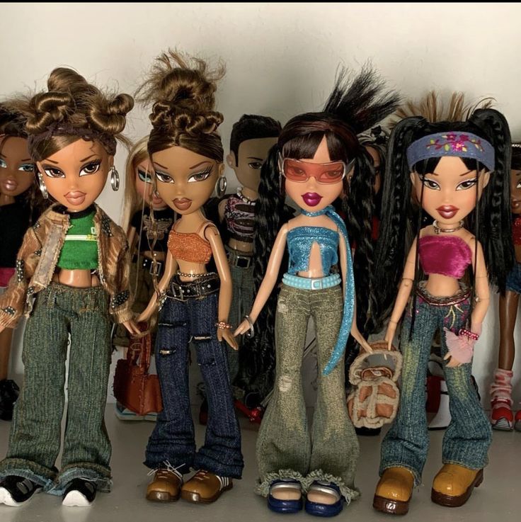 a group of dolls standing next to each other in front of a wall with many different hair styles