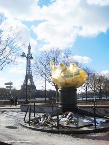 there is a large yellow sculpture in the middle of this park near the eiffel tower