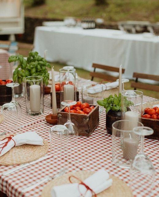 the table is set with plates, cups, and utensils for an outdoor meal