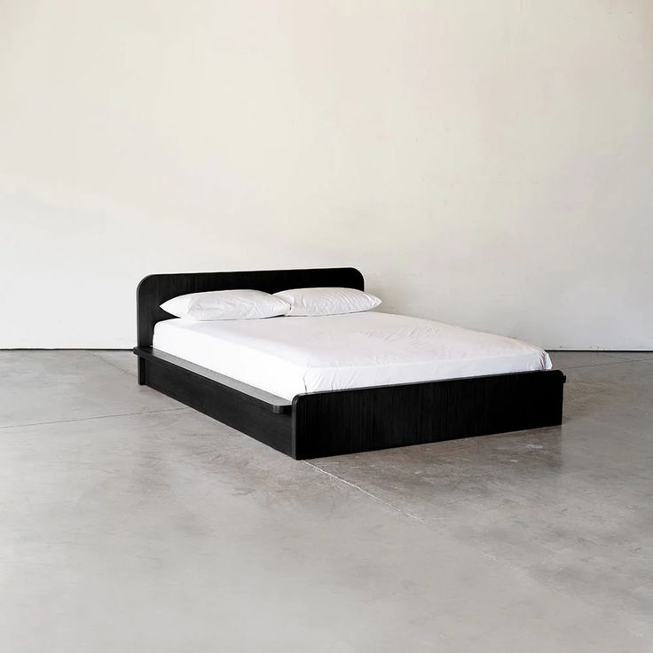 a bed sitting in the middle of a room with no sheets on top of it