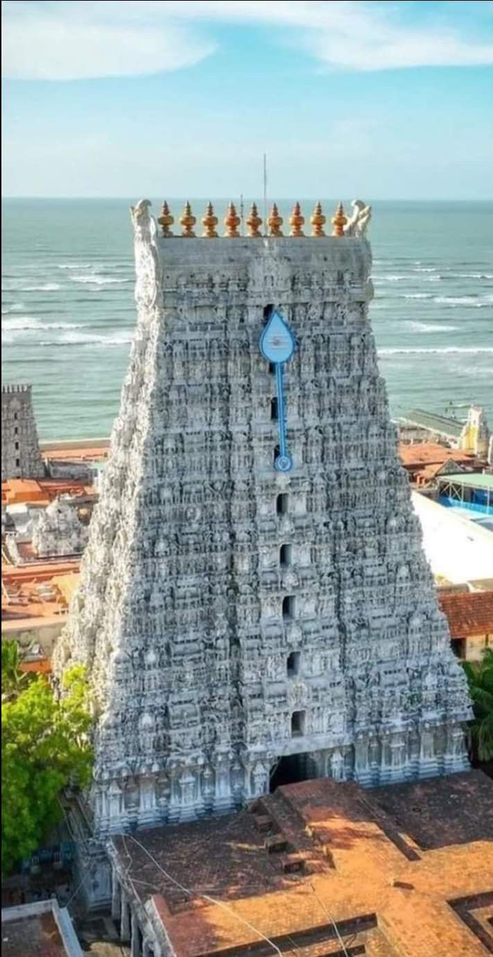 an aerial view of a very tall building next to the ocean