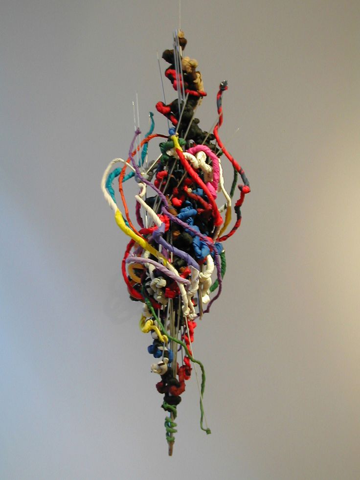 a multicolored sculpture hanging from the ceiling with strings attached to it's sides