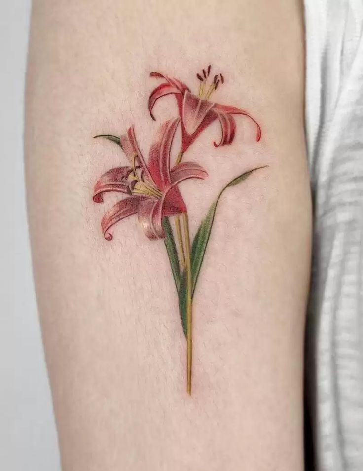 a close up of a person's arm with a flower tattoo on the side