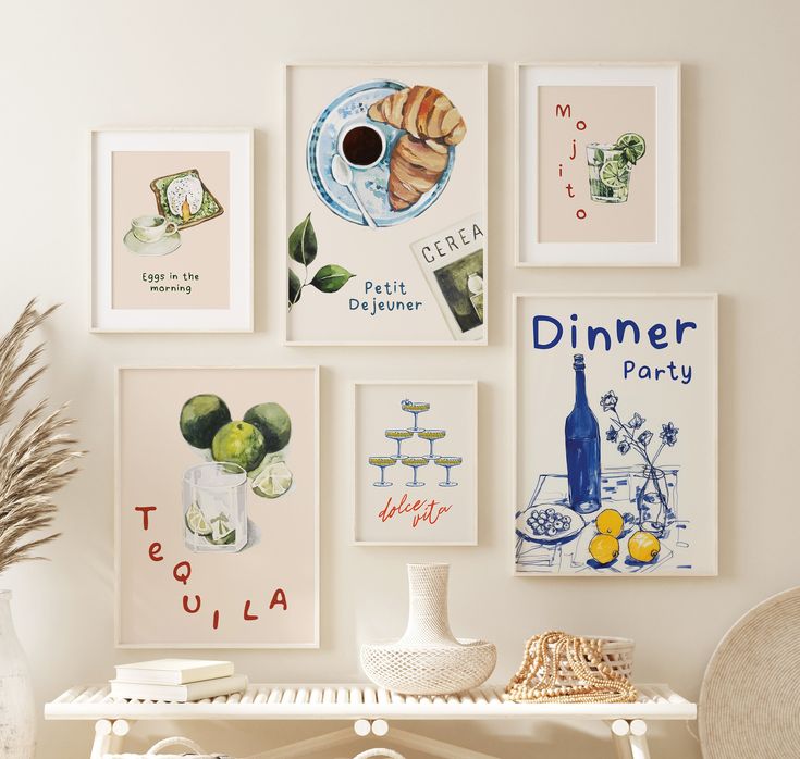 a white table topped with pictures and vases next to a wall covered in posters