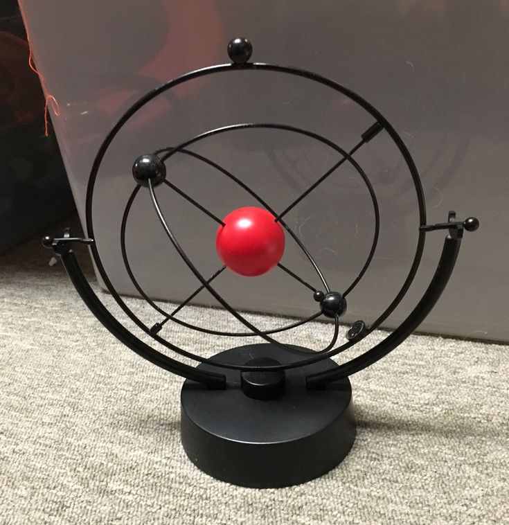 a red ball sitting on top of a metal object