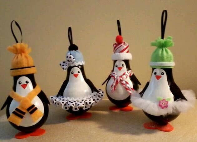 four penguin ornaments with hats and scarves on them