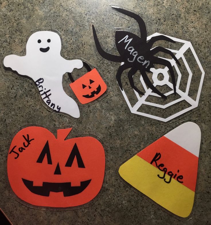 four halloween cutouts on a table with spider, jack - o - lantern and pumpkin